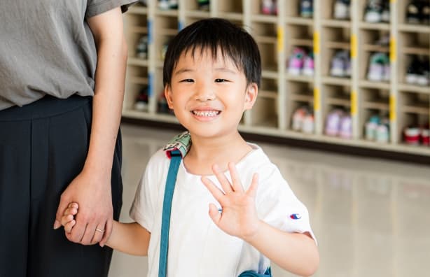 親と手をつないで帰る園児