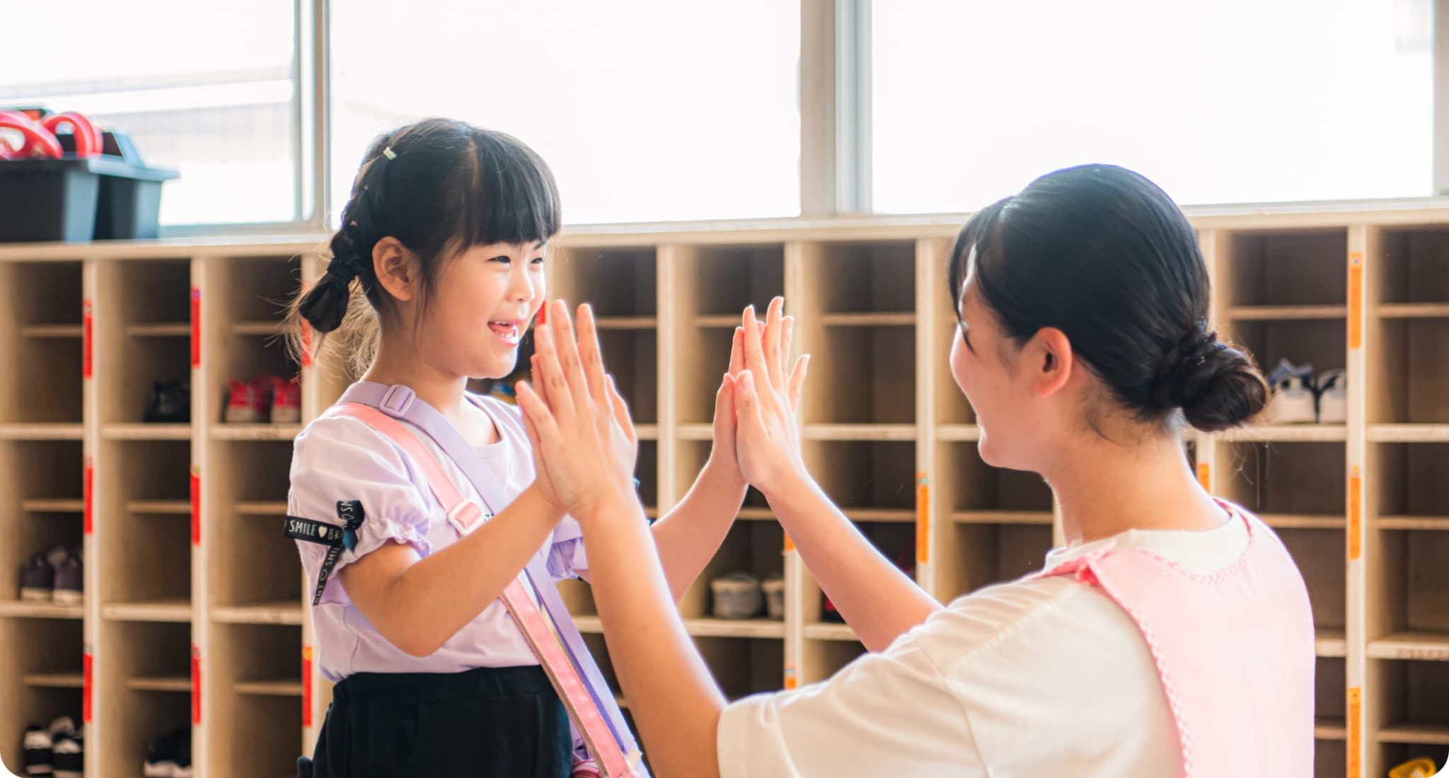 保育士と園児がハイタッチしている様子